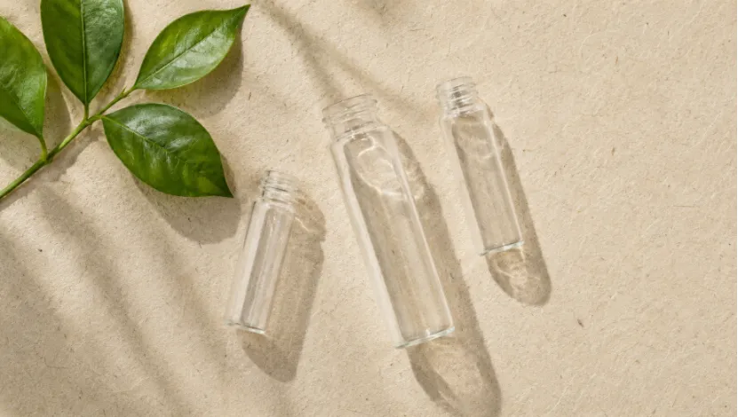 Three empty clear cosmetic glass tube bottles in various sizes