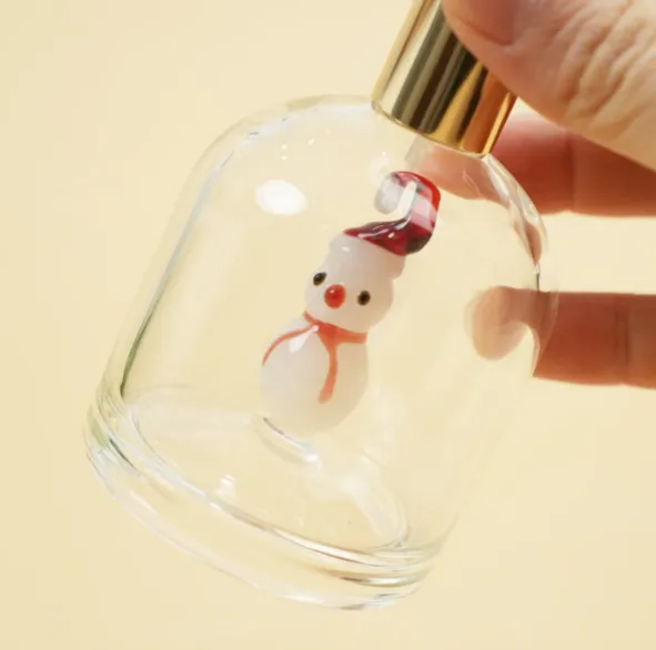 Clear perfume bottle with an inner glass snowman